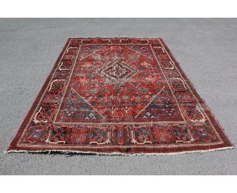 A Turkish Wool Carpet. The carpet of geometric patterns, claret ground heightened with white and turquoise.