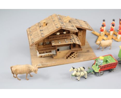 A Fine Wood Carved Model of a Swiss Chalet, complete with a small collection of farm animals and people.&nbsp;