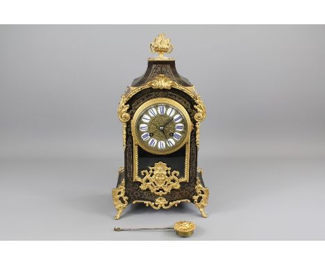 A 19th Century French Ebony and Ormolu Mantel Clock. The clock having a brass face with blue porcelain Roman dial stamped Par