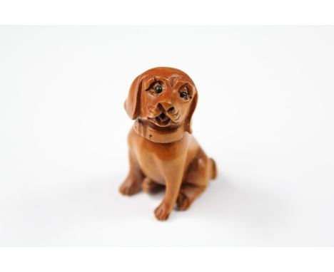 A Japanese Boxwood Netsuke, carved in the form of a seated dog, approx 45 mm, signed to base.&nbsp;