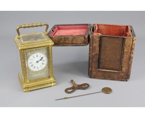 An English Gilt Brass Carriage Clock. The clock having a white enamel face with Roman dial. Silvered panels to side and dial 