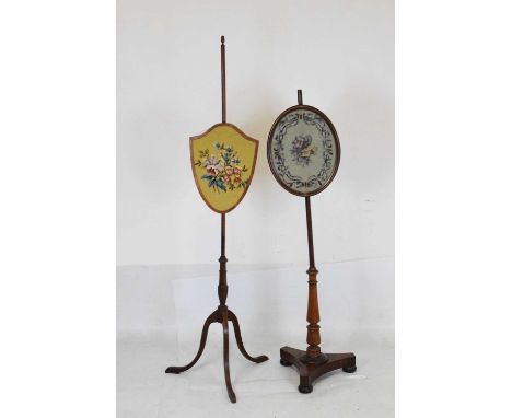 Two fire pole screens, one having shield tapestry panel with central floral spray on tripod support, 156cm high, the other ha