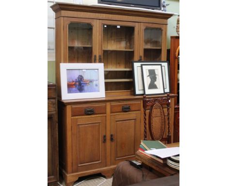 An early 20th century oak dresser with three in-line drawers over cupboard base. Three door glazed shelf unit above&nbsp;