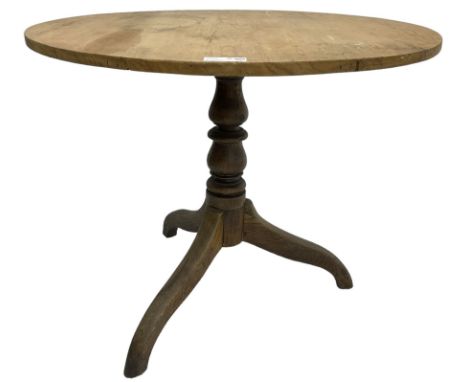 Early 19th century pine and elm tripod table; circular tilt-top over turned column and three splayed supportsDimensions: Heig