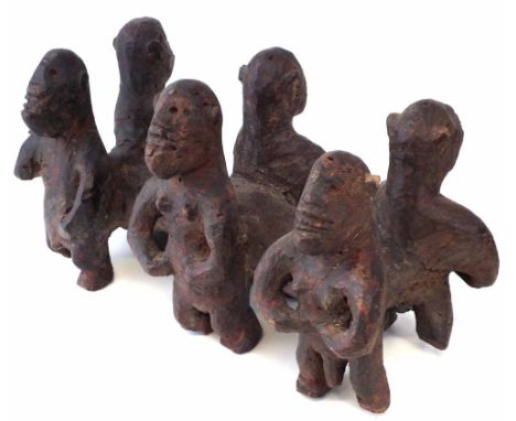 Unusual figure group possibly Bari or Sukuma, carved as six figures standing beside a log, 54cm long.       All lots in this 