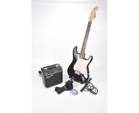 A Squire Fender Strat copy electric guitar late 20th CenturyBlack and cream bodied guitar with volume, tone (knobs) complete 