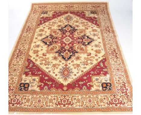 An ochre ground Heriz carpetThe central panel filled with star shaped flowerhead design detailed with ruby red panels and scr