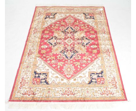A Heriz ochre ground rug The central cobalt blue, ruby red and amber coloured lozenge filled with flowers, tendrils and scrol