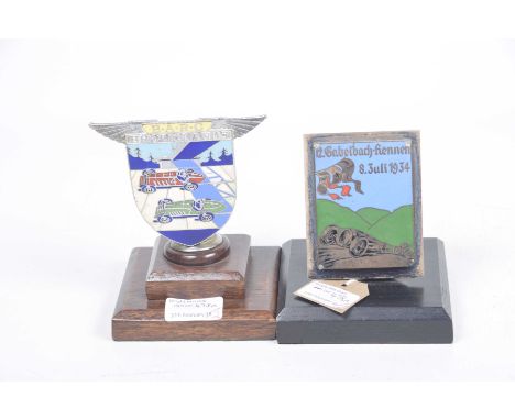 Two silver plated and enamel racing car mascots, early 20th CenturyFirst mascot motor car and bike racing, with inscription 1