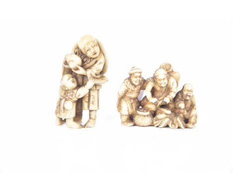 Two carved Japanese ivory netsuke, early 20th century Modelled as a father and boy, and figure group of four immortal group, 