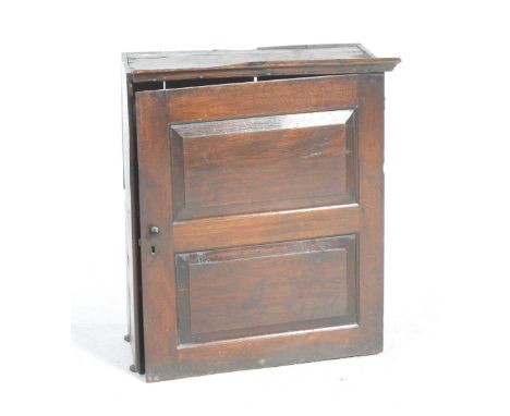 An 18th Century oak spice cupboard With a moulded cornice above a single panelled door enclosing two fixed shelves, 74x88x36c