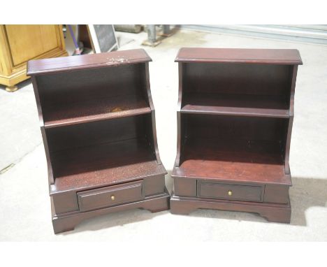 A pair of mahogany water fall bookcasesWith two graduated shelves above a plinth base with a single frieze drawer raised upon