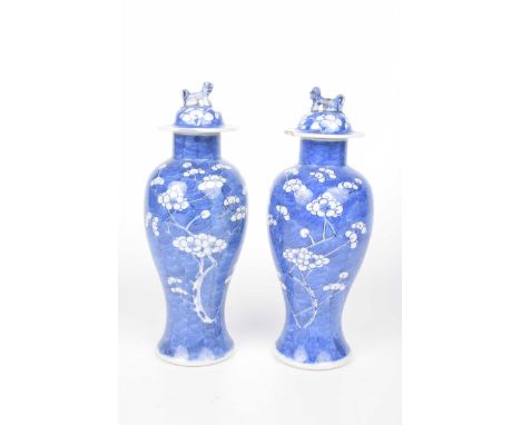 A pair of Chinese blue and white 'Prunus' vases and cover, Kangxi four-character mark Each of Meiping form, surmounted by a d
