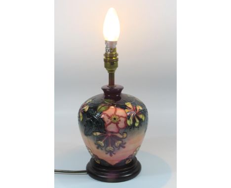 A MOORCROFT TABLE LAMP OF BULBOUS FORM, TUBELINED IN THE 'HONEYSUCKLE' PATTERN, ON A CIRCULAR STEPPED WOODEN BASE, MARKED,  W