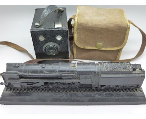 A carved coal figure of a locomotive and a Kodak Brownie Junior camera