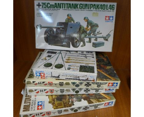 Four Tamiya military miniatures and one anti-tank gun