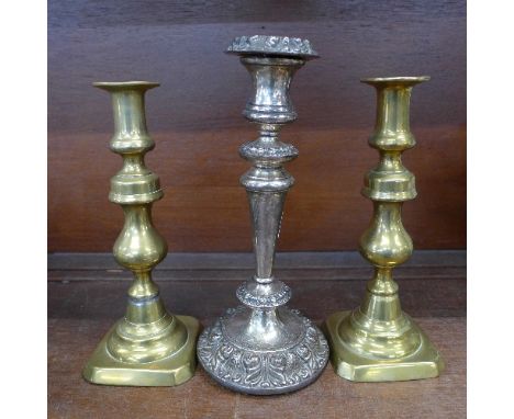 A plated candlestick and a pair of brass candlesticks