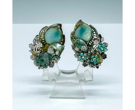 These traditionally vintage earrings feature a silver-toned leaf base adorned with layers of pearlized teal and silver-toned 