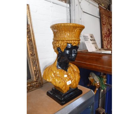 A GLAZED CERAMIC JARDINIERE in the form of a black boy, 51 cm high 