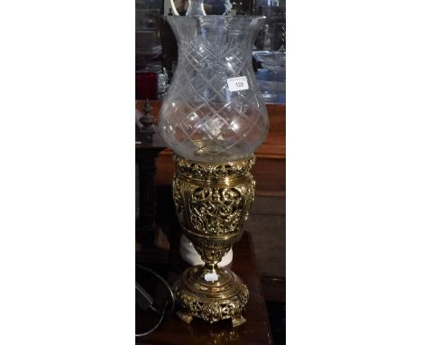 A VICTORIAN PIERCED BRASS OIL LAMP BASE, with a later glass storm lamp shade
