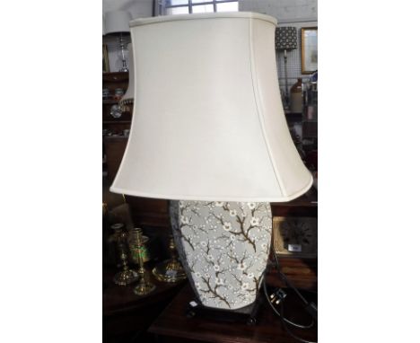 A TABLE LAMP IN THE FORM OF AN ORIENTAL VASE decorated with flowering blossom, on a wooden base, with a cream shade, 75 cm hi