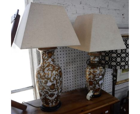 AN ORIENTAL STYLE TABLE LAMP, the white ceramic body with gilt floral decoration, 38cms high (not including fitting) and anot