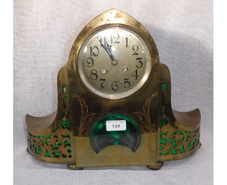 AN EARLY 20TH CENTURY BRASS-CASED MANTEL CLOCK, with engraved and pierced decoration, 33 cm high x 42" cm wide
