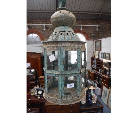 A CYLINDRICAL METAL LANTERN with green "verdigris" finish, with raised dome top and glazed sides, 51 cm high