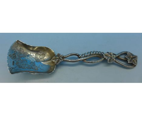 A silver caddy spoon decorated with grapevines, London 1899