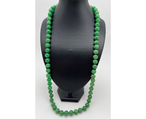 A 31" string of green apple jade beads, each bead approx. 1.2cm diameter. 