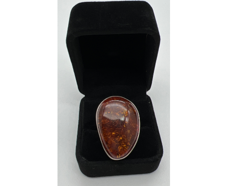 A very large cognac amber set silver dress ring. Stamped 925 to underside. Ring size PÂ½. Amber approx. 3.5cm x 2.5cm. Total 