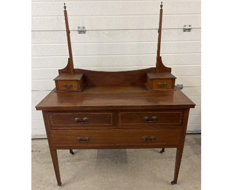 An Edwardian satin wood dressing table with inlaid detail and tapered legs, raised on ceramic caster feet. Mirror missing. Ap