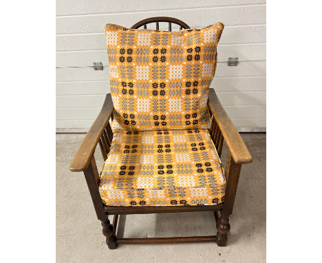 A vintage Arts &amp; Crafts style recliner dark wood chair with curved spindle back. With re upholstered seat and back cushio