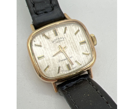 A ladies vintage 9ct gold case wristwatch with black leather strap by Rotary. Gold tone hour markers and hands with a brushed