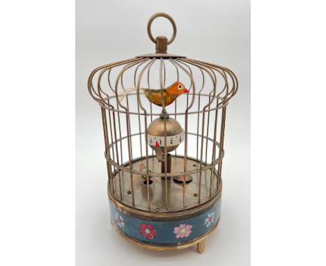 A brass ornamental wind up birdcage clock with winding mechanism to underside and blue cloisonne panelled detail. Both birds 