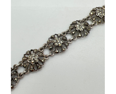 A vintage silver floral link bracelet with 10 pierced work links set with marcasite stones. Push clasp with safety chain. Sil