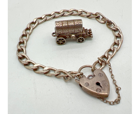A vintage silver curb chain charms bracelet with padlock and safety chain together with a white metal wagon charm. Wagon top 