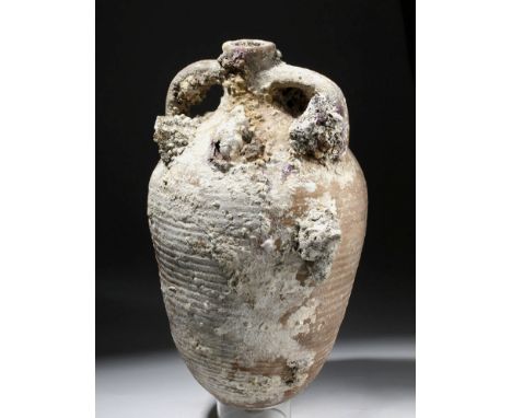 Roman, Imperial Period, ca. 1st to 3rd century CE. A beautiful pottery amphora with ribbed body, constricted rim, and applied