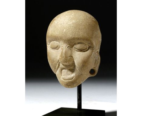 Pre-Columbian, Mayan Territories, Late Classic, ca. 550 to 900 CE. A smooth taupe colored limestone maskette pendant in the f