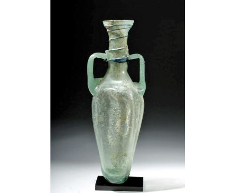 Roman Empire, Eastern Mediterranean, ca. 2nd to 3rd century CE. A unique translucent green glass vessel, a free blown form wi