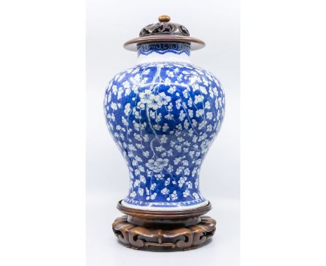 A Chinese Kangxi style baluster shaped blue and white jar, decorated with prunus before a ruyi border, with later carved hard