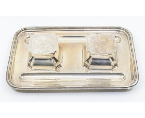 A George V silver double inkstand, rectangular with pen wells, geometric inkwell with ceramic bottles, on bun feet, D &amp; M