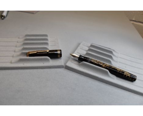 A Parker Vacumatic button fill fountain pen in brown transparent with three narrow bands to the cap having a Parker 14k nib. 