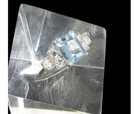 18ct white gold aquamarine and diamond dress ring in the Art Deco style, the emerald cut aquamarine flanked by six round bril