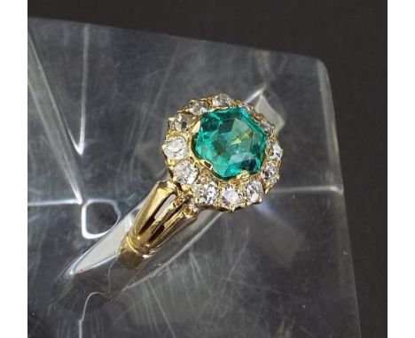 Emerald and diamond circular cluster ring, the emerald 1ct approx in a surround of old cut diamonds in a yellow gold setting,