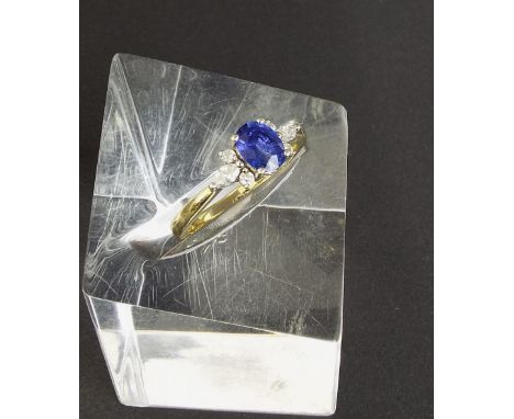 18ct sapphire and diamond ring, with an oval cut sapphire with a surround of six round brilliant and marquise cut diamonds, 0