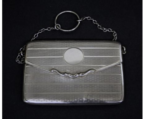 Early 20th century silver purse on a chain, with engine turned decoration, the spring hinge lid enclosing a gilded interior, 