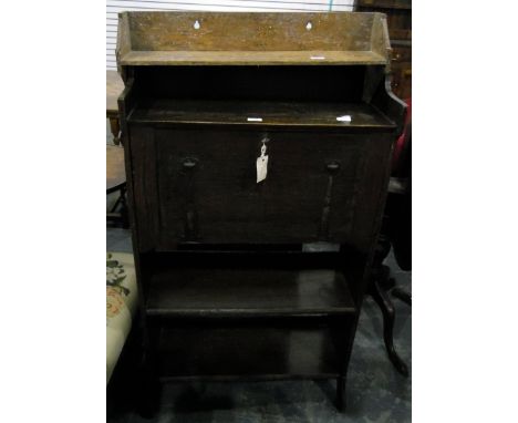 Late 19th century stained oak writing desk, the fall front with metal flowerhead strap hinges, fitted interior, two open shel