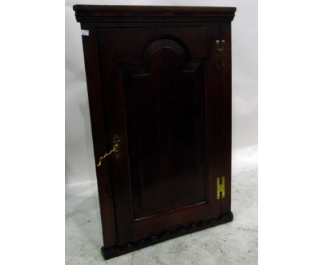 Georgian oak corner cupboard, the arched fielded panel door enclosing shelves, with H-brass hinges and scrollwork carved apro