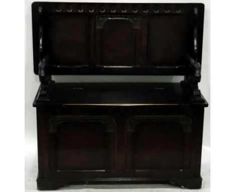 Stained oak monk's bench with rising top and box seat, carved panels, on bracket feet, width 101cm 